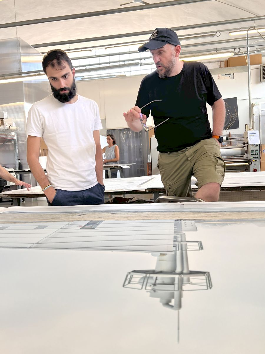 Luca Locatelli insieme al suo assistente controllano una stampa fine art di grandissimo formato pronta per l'incorniciatura